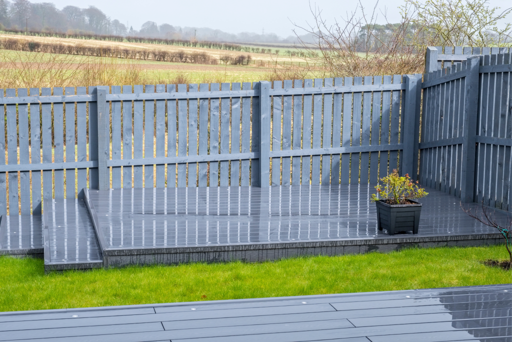 Grey Composite Decking Used In The Corner Of A Garden- Assured Composite